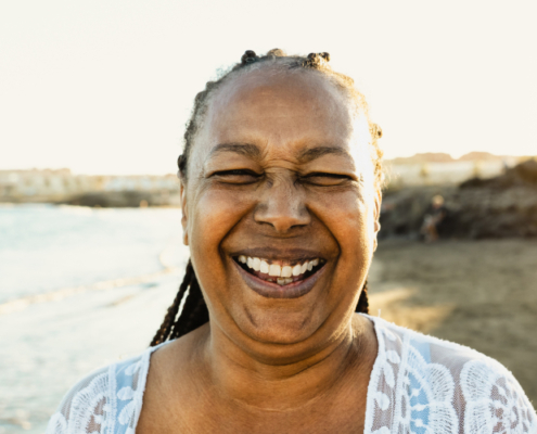 Michelle beaming with joy on the beach after achieving financial freedom through credit repair